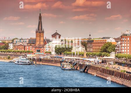 Recognizable architectural towers of the city of Dusseldorf and transportation waterway of the whole of Germany - Rhine River, along which large barge Stock Photo