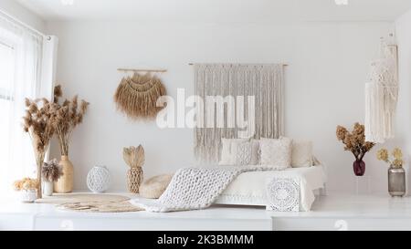 Empty cozy white bedroom made in ethnic style, panorama Stock Photo