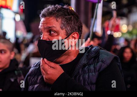 Toronto, Canada. 24th Sep, 2022. A masked protester rallies others on the streets under neon lights at night. Hundreds gathered to honour Mahsa Amini and to protest against the Iranian government in Toronto, Canada. Credit: SOPA Images Limited/Alamy Live News Stock Photo