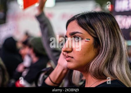 Toronto, Canada. 24th Sep, 2022. A woman with the colours of the Iranian flag painted on her face stands in a crowd of protesters during the rally. Hundreds gathered to honour Mahsa Amini and to protest against the Iranian government in Toronto, Canada. Credit: SOPA Images Limited/Alamy Live News Stock Photo