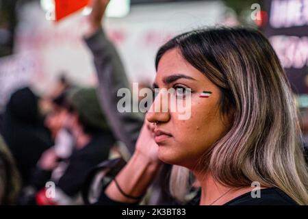 September 23, 2022, Toronto, Ontario, Canada: A woman with the colours of the Iranian flag painted on her face stands in a crowd of protesters during the rally. Hundreds gathered to honour Mahsa Amini and to protest against the Iranian government in Toronto, Canada. (Credit Image: © Katherine Cheng/SOPA Images via ZUMA Press Wire) Stock Photo