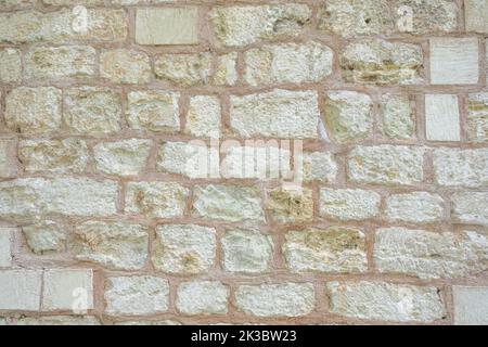 Wall with white bricks front view, orange white pattern with stones, texture stone material, vintage textured old wall, background concept Stock Photo