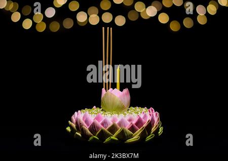 Selective focus on Lotus flower of pink lotus petal krathong on night background with bokeh light for Thailand full moon or Loy krathong festival. Stock Photo