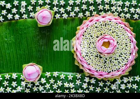 Pink lotus petal krathong decorates with its flower, crown flower for Thailand Full moon or Loy Krathong festival on banana leaves background. Stock Photo