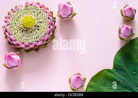 Pink lotus petal krathong for Thailand Loy Krathong festival decorates with its pollen and crown flower on pink background with lotus flower and leaf. Stock Photo