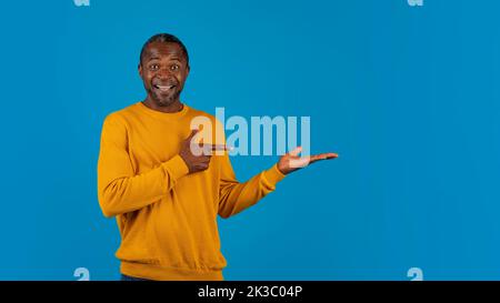 Happy black man showing something on his hand Stock Photo