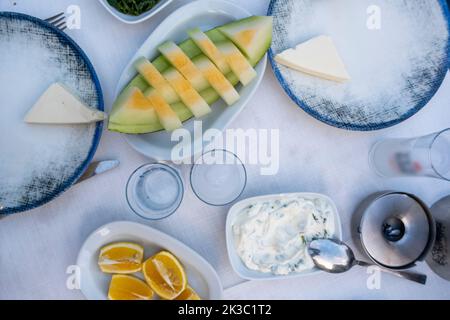 Traditional Turkish alcohol known as Rakı, Turkish Raki table with melon lemon and appetizer, chill with friends at restaurant, dinner and meal idea Stock Photo