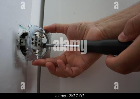 male hand repairing the socket Stock Photo