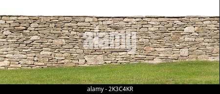 Light brown yellow dry stone wall texture,  sloping ground with grass at the bottom, white cutout sky, sandstone garden wall background Stock Photo