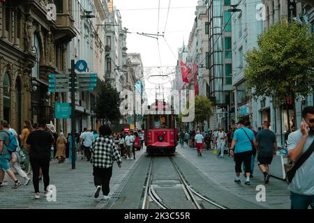 Istiklal street view with people, cityscape in Istanbul, front view of popular red tram, retro street with walking people, old train goes in crowded Stock Photo