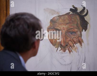 A gallery staff member poses next to a painting by Lucian Freud - Self-portrait (Fragment), 1956 - on show at a photocall for the Credit Suisse exhibition - Lucian Freud: New Perspectives at the National Gallery in London. Picture date: Monday September 26, 2022. Stock Photo