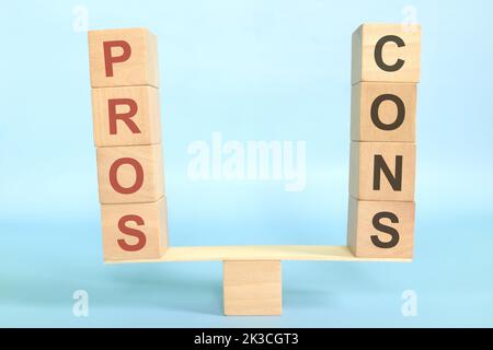 Balance and weigh in and pros versus cons concept. Pros and Cons word in seesaw in blue background. Stock Photo