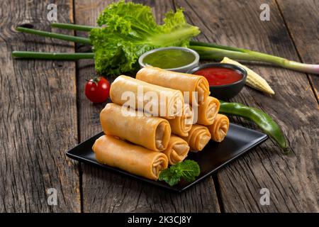 Fried spring rolls with sweet chili sauce and lime on plate Stock Photo