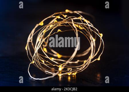 Fairy lights led garland coil, blurred. Christmas atmosphere concept on black Stock Photo