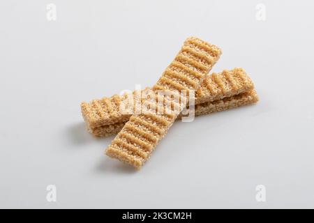 sesame seed candy bars, in a wooden bowl. Sesame brittle or crunch, a confection of sesame seeds and honey pressed into flat bars, a popular snack in Stock Photo