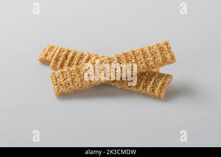 sesame seed candy bars, in a wooden bowl. Sesame brittle or crunch, a confection of sesame seeds and honey pressed into flat bars, a popular snack in Stock Photo