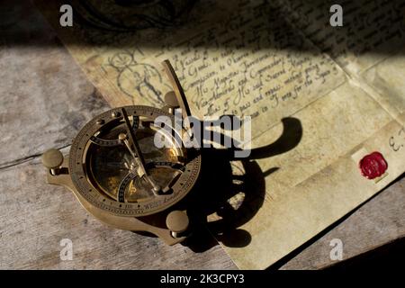 17th Century sudial compass resting on a Royal declaration to a ship's captain to commit acts of piracy against the British crown's enemies. Stock Photo
