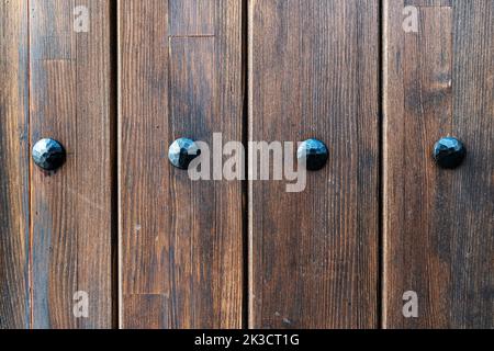An old grungy, brown, painted, natural wood with grains and big metal nails for background and texture. High quality photo Stock Photo
