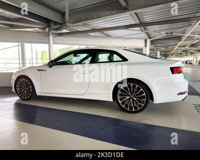 Basel, Switzerland - Sep 22, 2022: Lateral lower view of new white luxury Audi German car coupe parked in modern parking Stock Photo