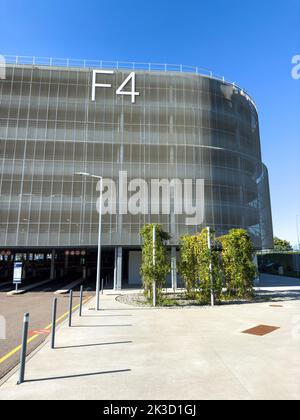 Basel, Switzerland - Sep 22, 2022: View from the street of Modern building of F4 parking at the EuroAirport - Basel Mulhouse Freiburg airport with large F4 sign on the facade with Jeep car driving by Stock Photo