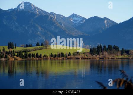 scenic view of lake Hopfensee and castle Neuschwanstein in the Bavarian Alps reflected in the calm lake  (Swabia, Bavaria, Germany) Stock Photo