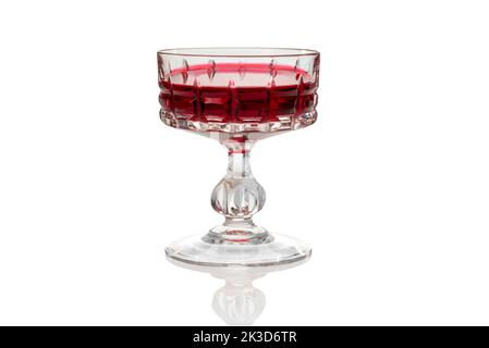 Vintage glass with Alchermes, Cassis red blackcurrant liqueur in antique glass isolated on white, clipping path Stock Photo
