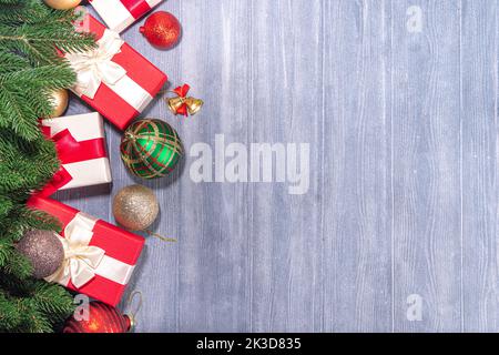 Present Boxes With Christmas tree on wooden background. Various red and white gifts with festive ribbon, fir tree branches and Xmas decoration on old Stock Photo