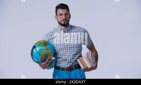 nerd student with globe and stack of books looking at camera isolated on grey,stock image Stock Photo