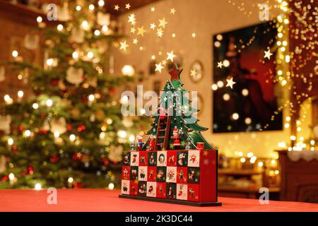 Three-dimensional Advent Calendar with stylised Christmas Tree in the middle of Christmassy illuminated Family Room Stock Photo