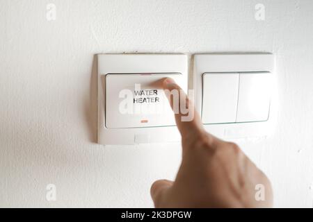 A finger turning on lighting switch . Stock Photo