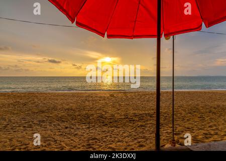 View of the beautiful sunset above beach at Koh Lanta island, Thailand. Look from the shadow of beach umbrella. Vibrant and soft light, colorful conce Stock Photo