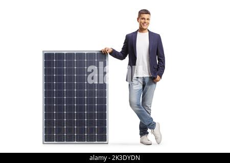 Young man leaning on a solar panel and smiling isolated on white background Stock Photo