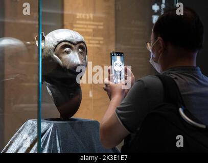 (220926) -- SHANGHAI, Sept. 26, 2022 (Xinhua) -- A visitor takes photos of a bronze monkey head at the exhibition 'Return in Golden Age: China's Retrieved Cultural Relics Exhibition' in east China's Shanghai, Sept. 26, 2022. 'Return in Golden Age: China's Retrieved Cultural Relics Exhibition' was launched Monday at the Minhang Museum in east China's Shanghai. The exhibition features China's cultural relics retrieved from overseas and now kept by the Poly Art Museum and the administration office of the Yuanmingyuan. Among the exhibits are bronze Chinese zodiac animal heads that belonged to the Stock Photo