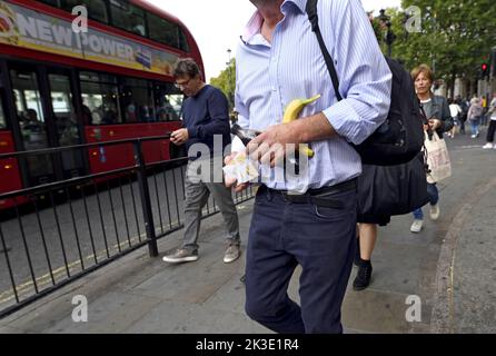 London, England, UK. Man carrying his lunch - sandwiches, bottle of Coke and a banana in Trafalgar Square Stock Photo