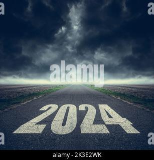 2024 written on highway road in the middle of asphalt road and dark cloudy sky. Stock Photo