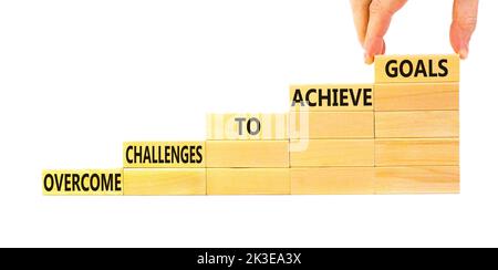 Overcome challenges to achieve goals symbol. Concept words Overcome challenges to achieve goals on wooden blocks on a beautiful white background. Busi Stock Photo