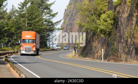 Nehalem, OR, USA - September 21, 2022; Orange truck travelling southbound through curves on Pacific Coast Highway in Oregon Stock Photo