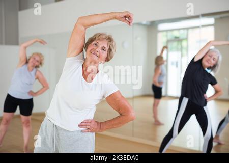 Portrait of mature energetic woman practicing active dancing at a group lesson Stock Photo
