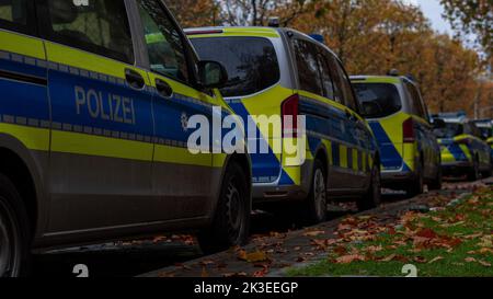 German police cars by the sidewalk in autumn Stock Photo