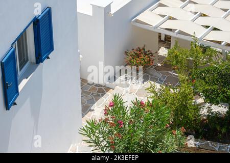 A white washed house with blue window shutters and a balcony in Ios Greece Stock Photo