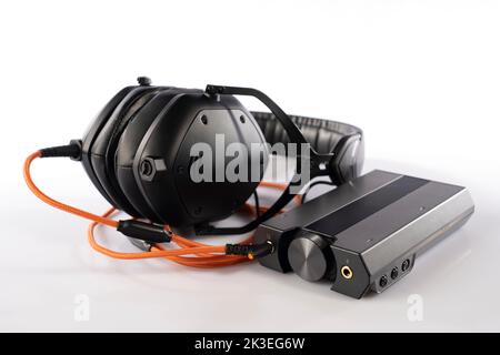 External sound card and DAC connected to headphones with the orange cable isolated on white Stock Photo