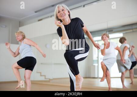 Portrait of mature energetic woman practicing active dancing at a group lesson Stock Photo