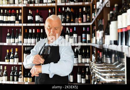 senior man professional sommelier tasting red wines Stock Photo