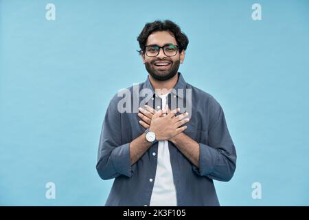 Grateful happy arab man holding hands on chest isolated on yellow. Stock Photo