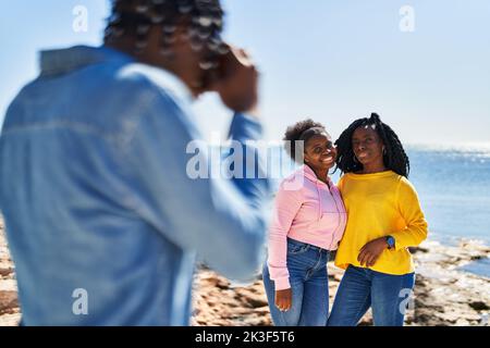 African american friends hugging each other making photo at seaside Stock Photo