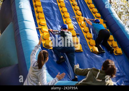 People passing obstacles on inflatable arena at amusement park Stock Photo