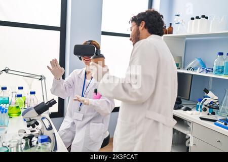 Man and woman scientist partners using vr goggles and drinking coffee at laboratory Stock Photo