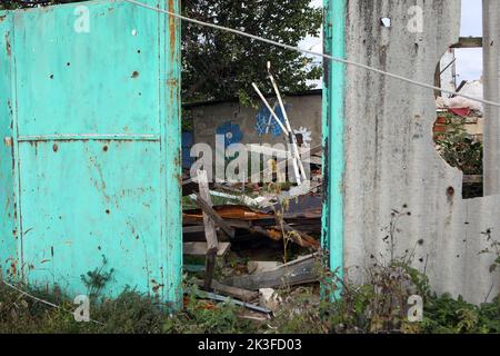 KHARKIV REGION, UKRAINE - SEPTEMBER 26, 2022 - Aftermath of hostilities in the village of Dementiyivka recently liberated from russian invaders, partially damaged fence, Kharkiv Region, north-eastern Ukraine. Stock Photo