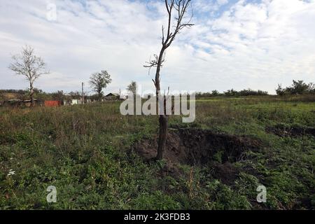 KHARKIV REGION, UKRAINE - SEPTEMBER 26, 2022 - Aftermath of hostilities in the village of Dementiyivka recently liberated from russian invaders, a shell hole, Kharkiv Region, north-eastern Ukraine. Stock Photo