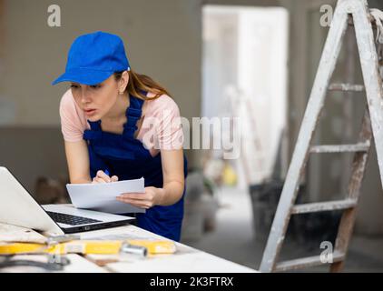 Woman architect using laptop at renovating apartment Stock Photo